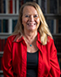 Laura Turchi portrait photograph smiling by bookcase