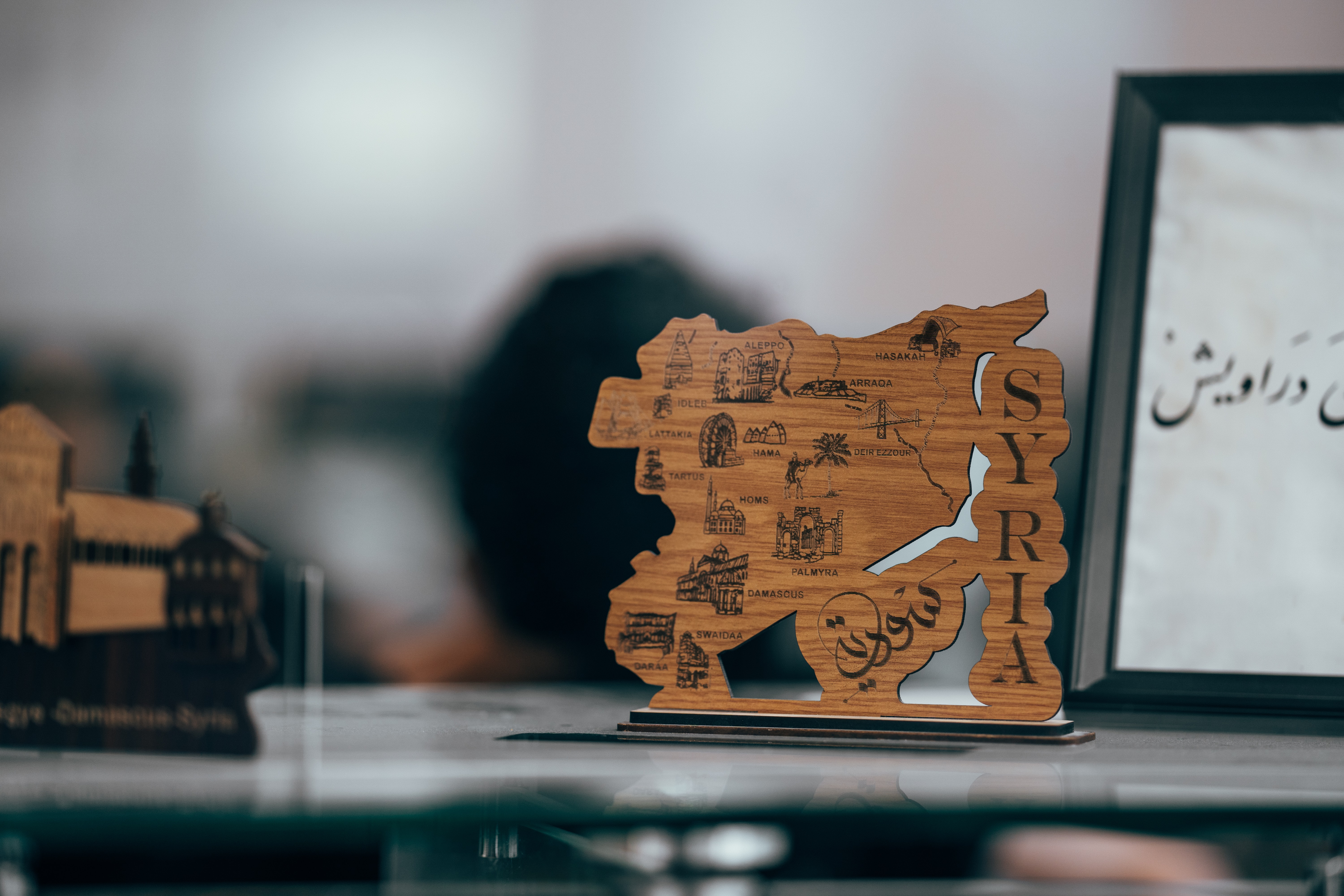 Wood carving shaped as Syria with Arabic writing