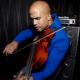 Daniel Roumain portrait photograph playing violin with bow passing over the strings